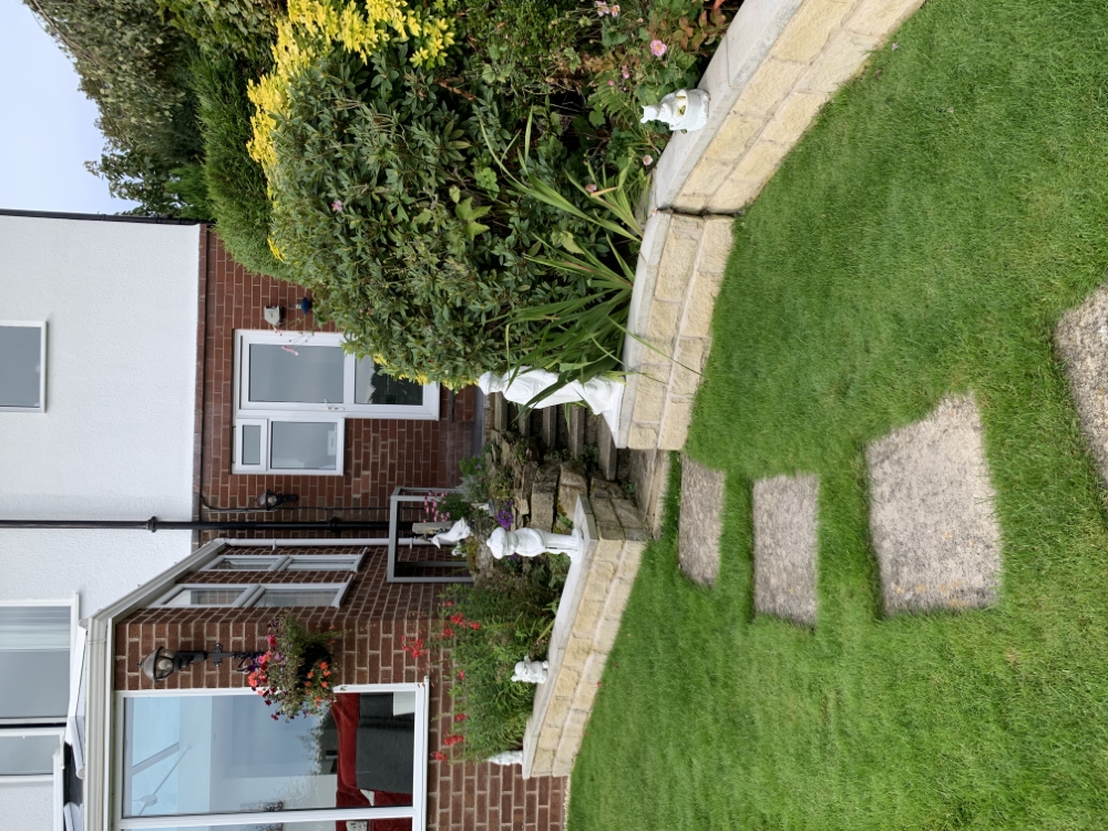 Tidy lawn and raised flower beds beside a house